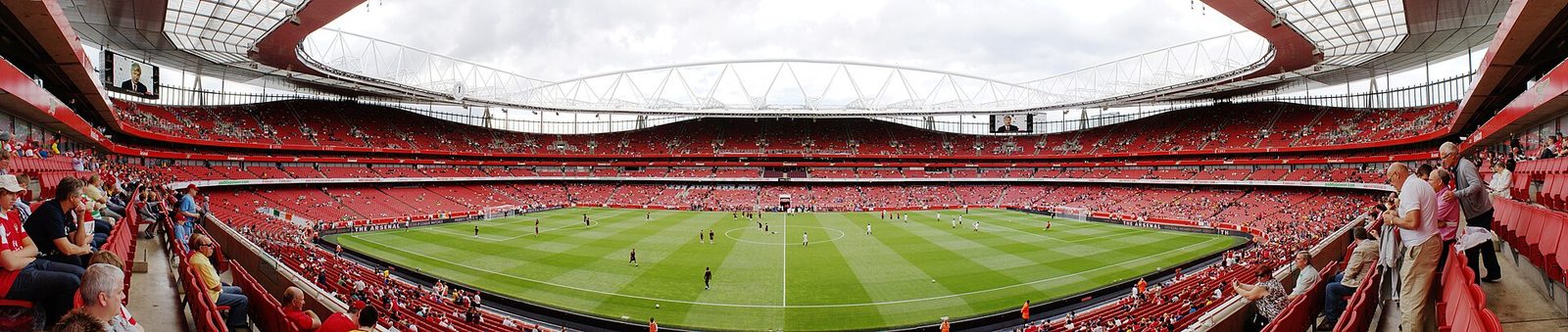 Vista panorámica del interior del Emirates Stadium durante un partido, con el césped verde en el centro