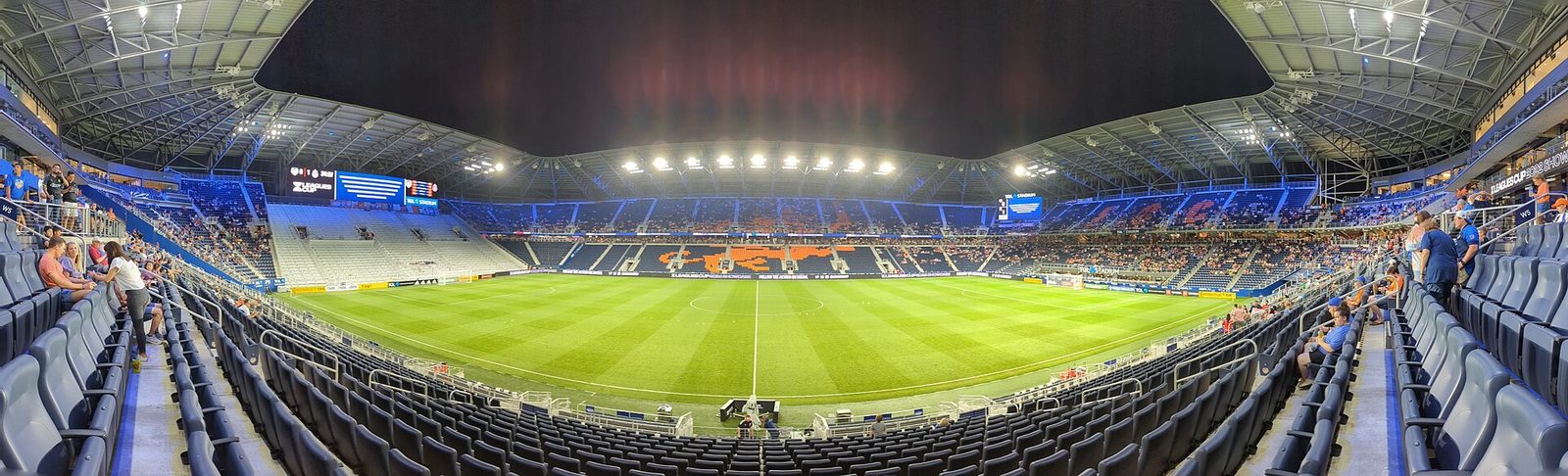 Interior panorámico de un estadio de la MLS de noche, con el césped rayado iluminado y las tribunas alrededor