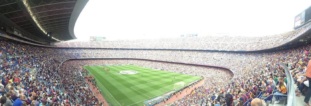 Panorámica del Camp Nou con las gradas completas y el césped verde del campo en el centro