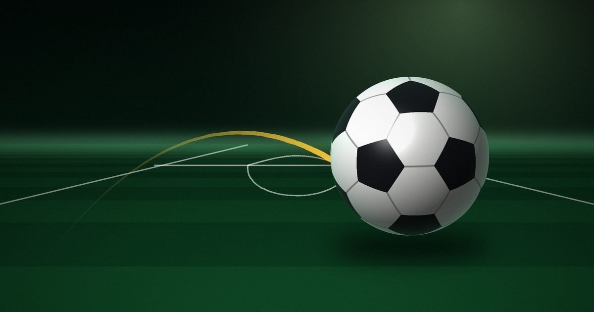 Balón de fútbol sobre el césped de un estadio de noche