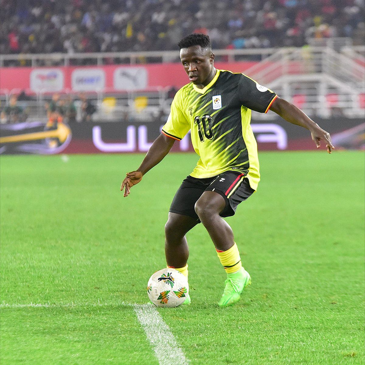 Uganda footballer drives the ball against Algeria