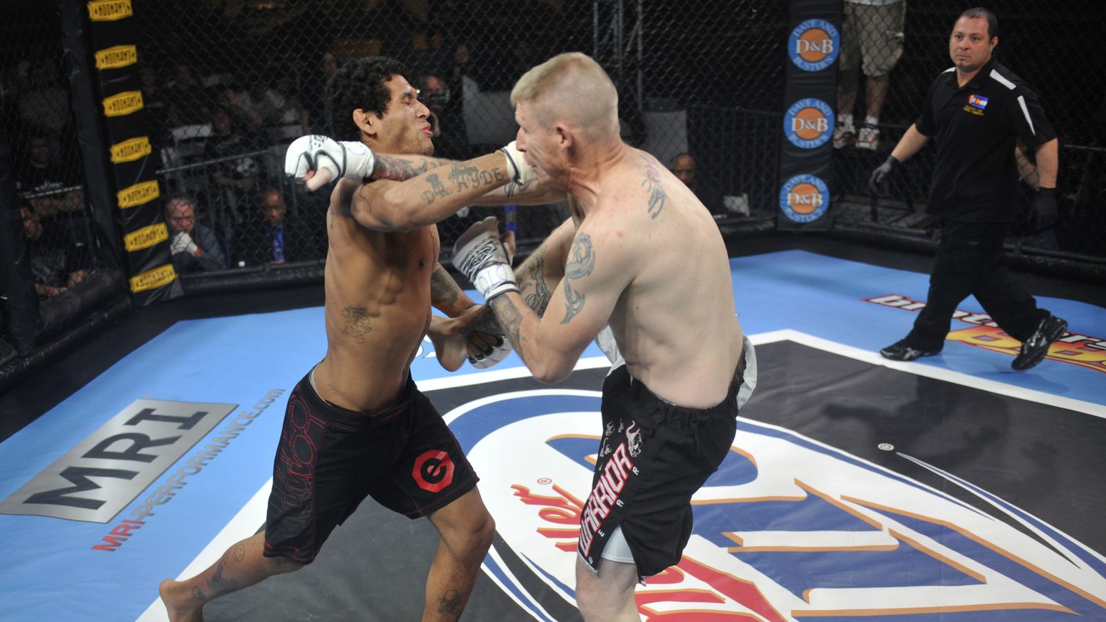 Dos peleadores de MMA en el suelo de una jaula durante un combate